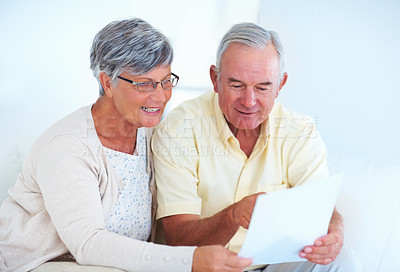 Buy stock photo Home, senior couple and budget with document for finance, track expenses and discussion with bill. Communication, man and woman with paper for checking, savings and review investment in retirement