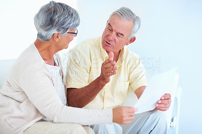 Buy stock photo Happy mature couple discussing while reading letter at home