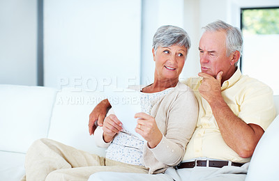 Buy stock photo Loving mature couple discussing home finance while sitting on couch