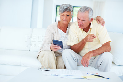 Buy stock photo Mature couple calculating home budget while sitting on couch