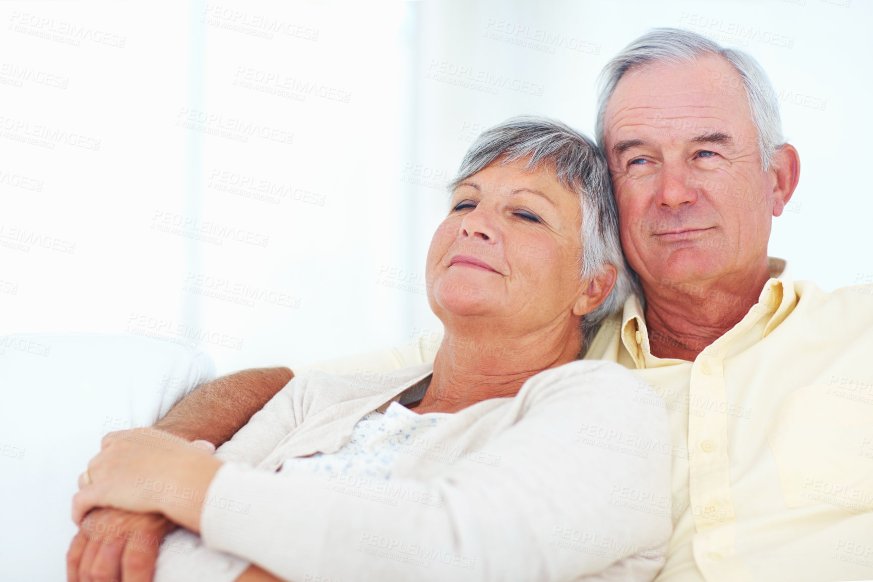 Buy stock photo Senior couple, trust and hug in home, security and love in marriage connection on couch. Elderly people, embrace and commitment to relationship in retirement, bonding and support for comfort on sofa