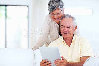 Buy stock photo Happy mature couple using tablet PC at home