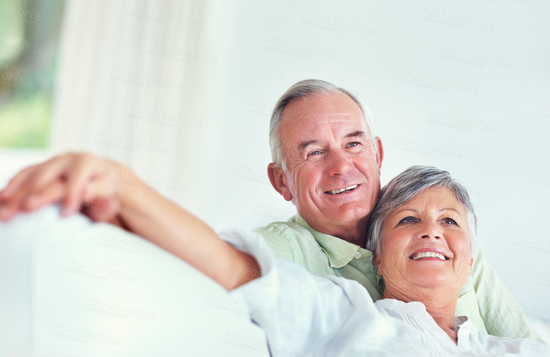 Buy stock photo Senior couple, smile and hug on sofa for relax, bonding and love with support, care and together in home. Elderly people, happy and comfort on couch for weekend break, marriage and embrace with trust