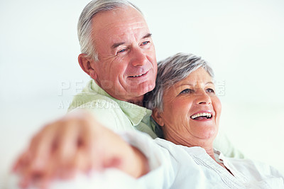 Buy stock photo Loving mature couple smiling while relaxing on couch
