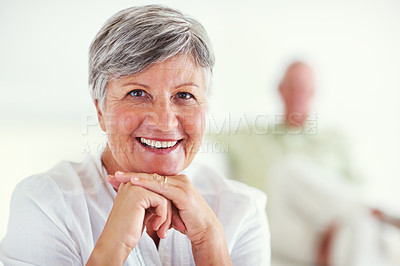 Buy stock photo Portrait of mature woman smiling with blurred man in background