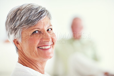 Buy stock photo Closeup of pretty mature woman smiling with man in background