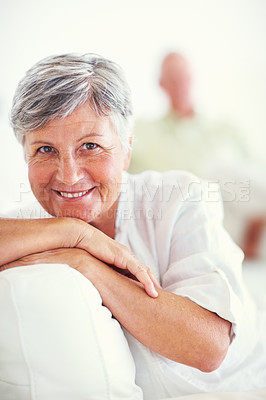 Buy stock photo Portrait of beautiful mature woman smiling with man in background at home
