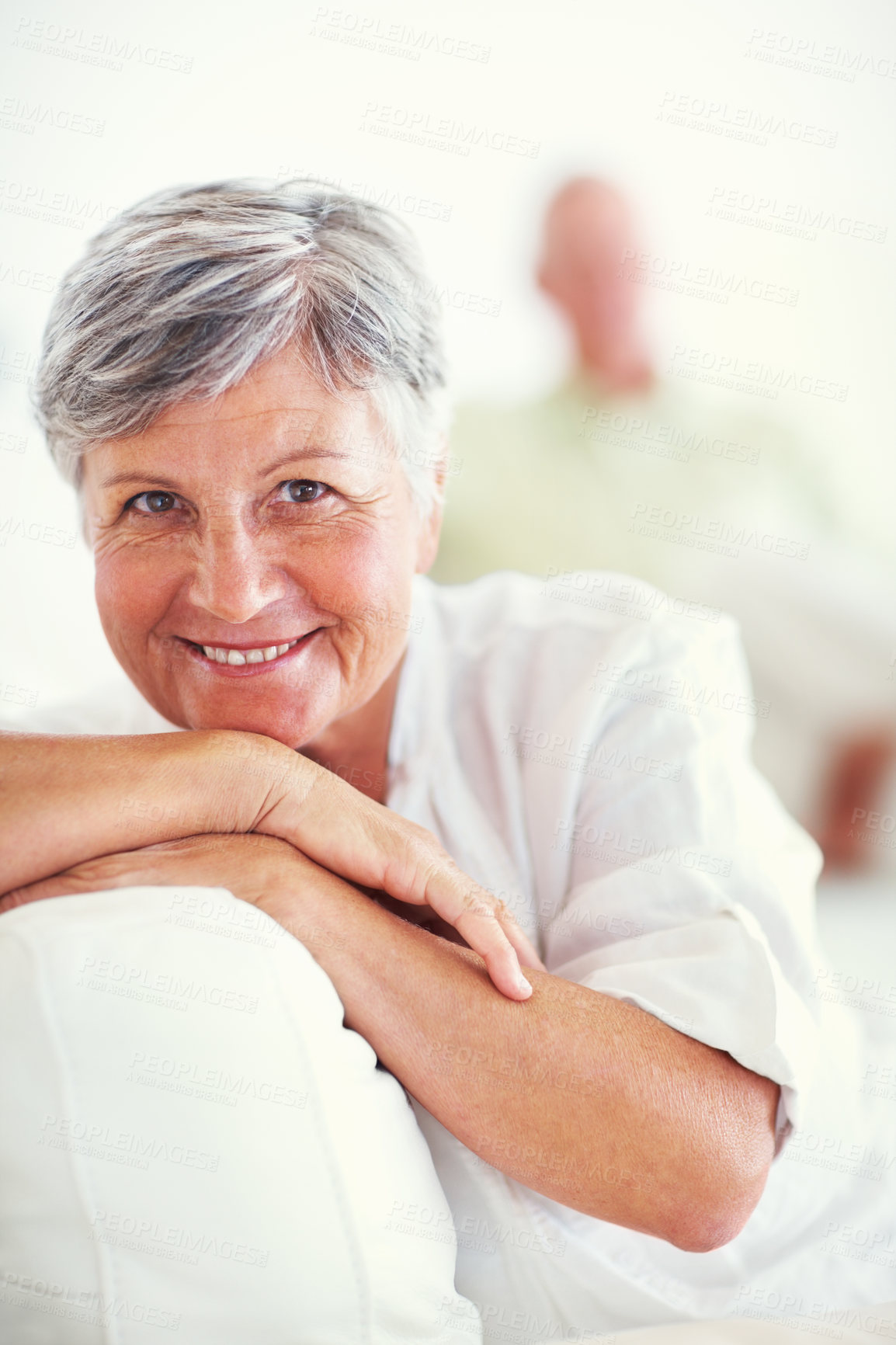 Buy stock photo Portrait of beautiful mature woman smiling with man in background at home