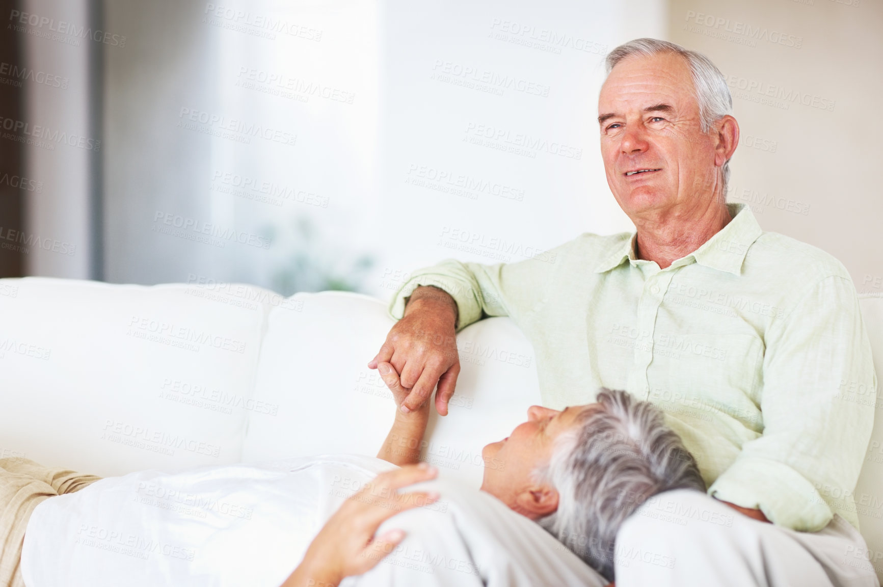 Buy stock photo Senior couple, happy and lying on sofa for relax, bonding and love with support, care and together in home. Elderly people, smile and comfort on couch for weekend break, marriage and holding hands