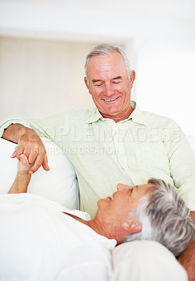 Buy stock photo Senior couple, happy and love on sofa for relax, bonding and trust with support, care and together in home. Elderly people, smile and comfort on couch for weekend break, marriage and holding hands