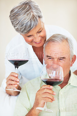 Buy stock photo Happy mature couple smiling while drinking wine at home