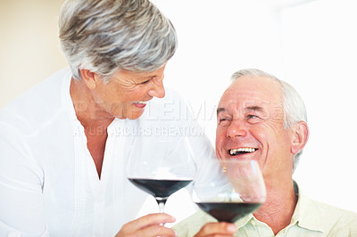 Buy stock photo Senior couple, glasses and toast in home, marriage anniversary and growth in partnership. Elderly people, romance and cheers with red wine for love celebration, happy milestone and bonding on date