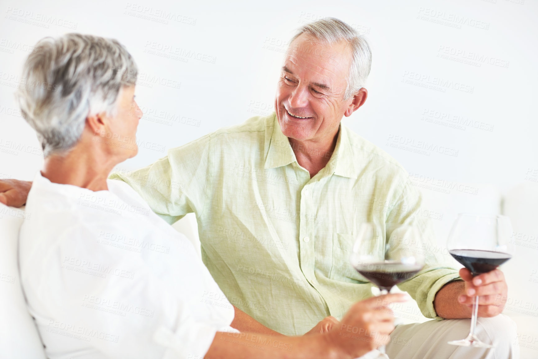 Buy stock photo Senior couple, wine and talking in home, marriage anniversary and growth in partnership. Elderly people, romance and chat with alcohol glasses for love celebration, milestone and bonding on date