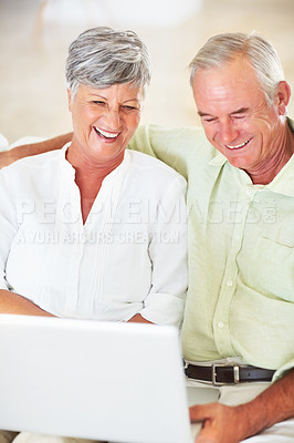 Buy stock photo Senior couple, laptop and home for blog, surfing social media and internet for communication. Elderly people, relax and together for bonding in living room, reading funny ebook and streaming comic