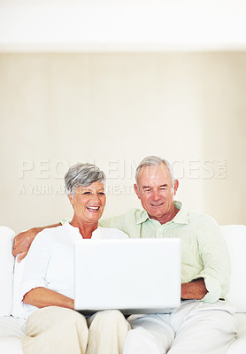 Buy stock photo Couch, senior couple and laughing with laptop for movie, comedy film and entertainment in retirement. Happy people, woman and man with digital for streaming series, online video and bonding at home