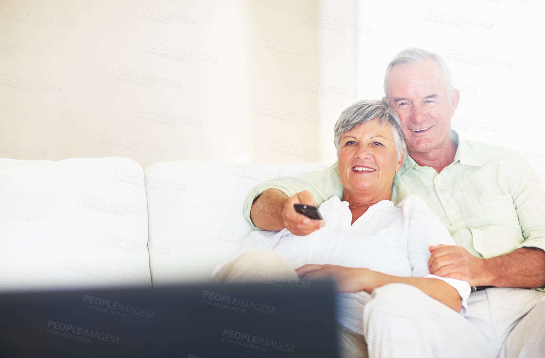 Buy stock photo Relaxed mature couple watching television in living room