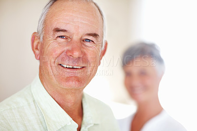 Buy stock photo Portrait of good looking mature man smiling with woman in background