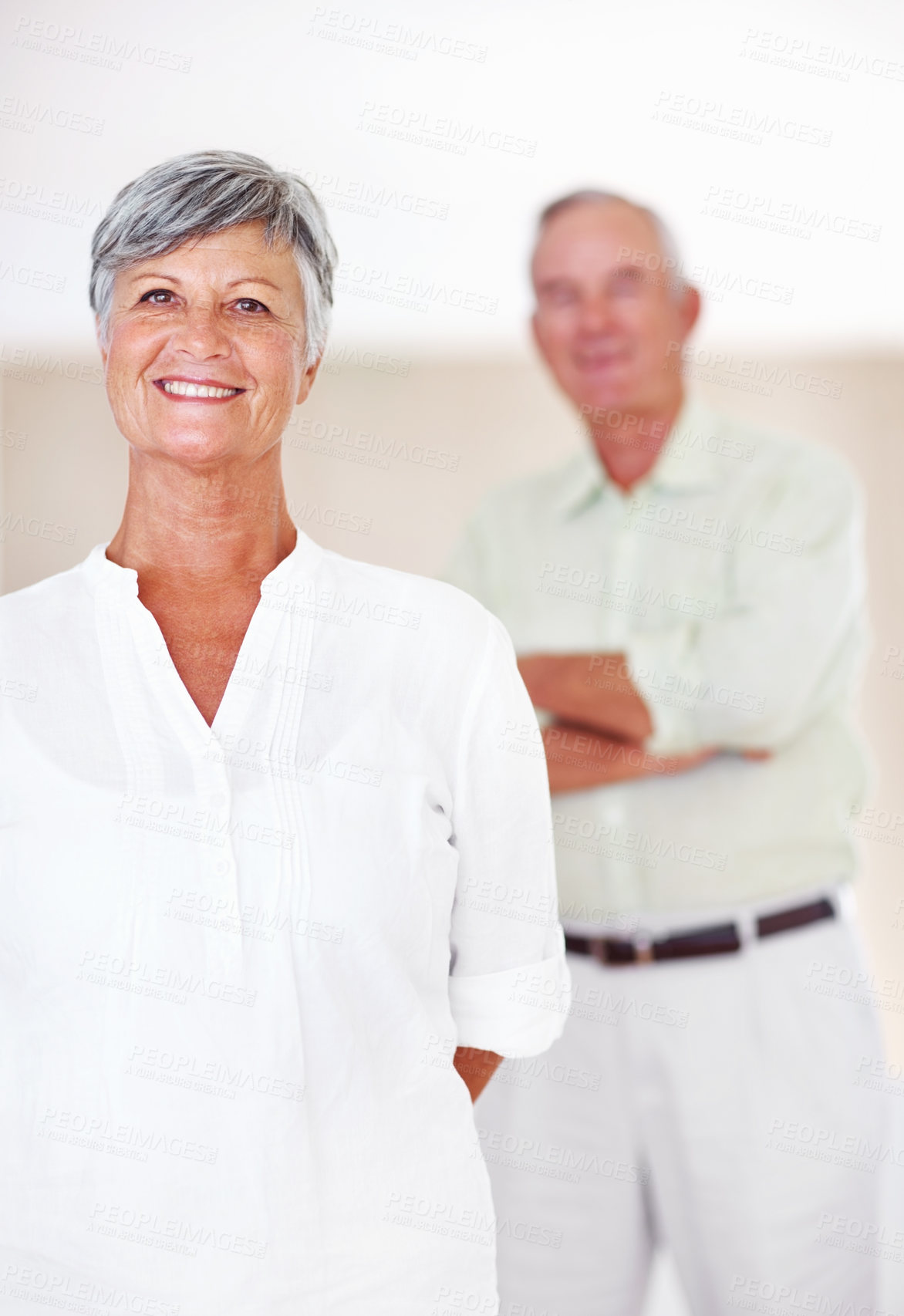 Buy stock photo Portrait of beautiful mature woman smiling with man standing in background