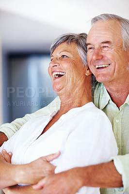 Buy stock photo Elderly couple, laughing and hug in home for relax, bonding and love with support, care and romance. Senior people, funny and connection in house for weekend break, marriage and embrace with trust