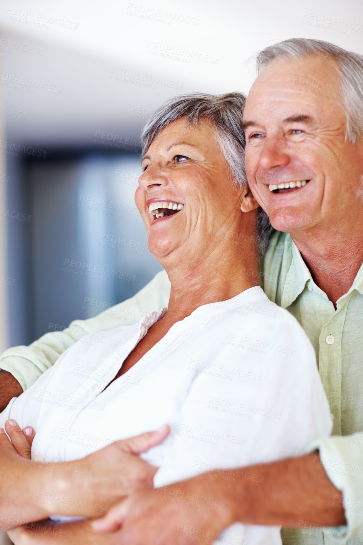 Buy stock photo Elderly couple, laughing and hug in home for relax, bonding and love with support, care and romance. Senior people, funny and connection in house for weekend break, marriage and embrace with trust