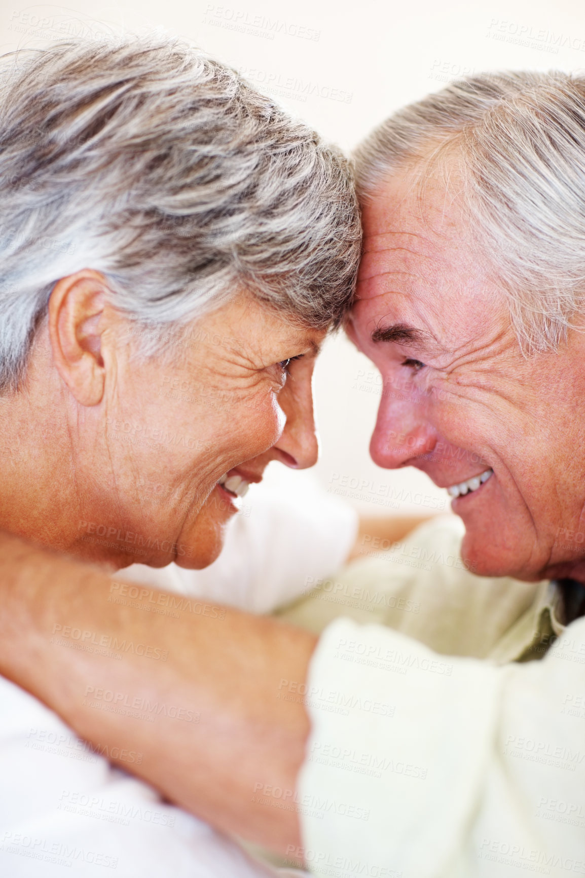 Buy stock photo Closeup of affectionate mature couple smiling while looking at each other, head to head