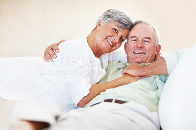 Buy stock photo Elderly couple, couch and portrait in home for relax, bonding and love with support, care and romance. Senior people, smile and connection in house for weekend break, marriage and embrace with hug