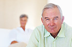 Smiling mature man with woman in background