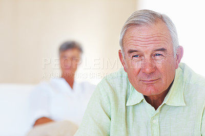 Buy stock photo Closeup of handsome mature man at home with woman in background