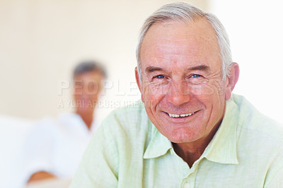 Buy stock photo Portrait of mature man smiling at home with woman in background