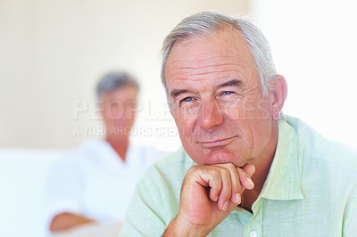 Buy stock photo Closeup of thoughtful mature man smiling at home with woman in background