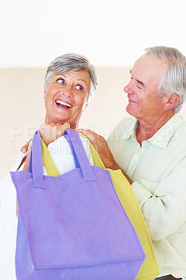 Buy stock photo Excited mature woman carrying shopping bags with mature man