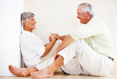 Buy stock photo Senior couple, happy and holding hands for love, relax and bonding in house with smile, care or support. Man, woman and romance in apartment for relationship, marriage and communication with trust