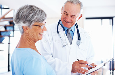 Buy stock photo Smiling mature doctor discussing medical report with happy patient