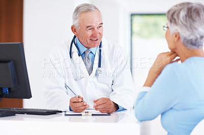 Buy stock photo Mature doctor discussing medical report with female patient