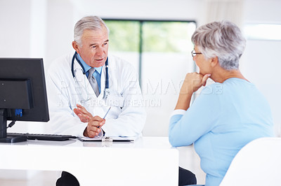 Buy stock photo Confident mature doctor discussing medical report with female patient