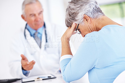 Buy stock photo Mature doctor discussing medical report with unhappy female patient