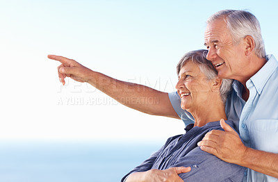 Buy stock photo Smiling mature man showing something to beautiful wife while spending time outdoors