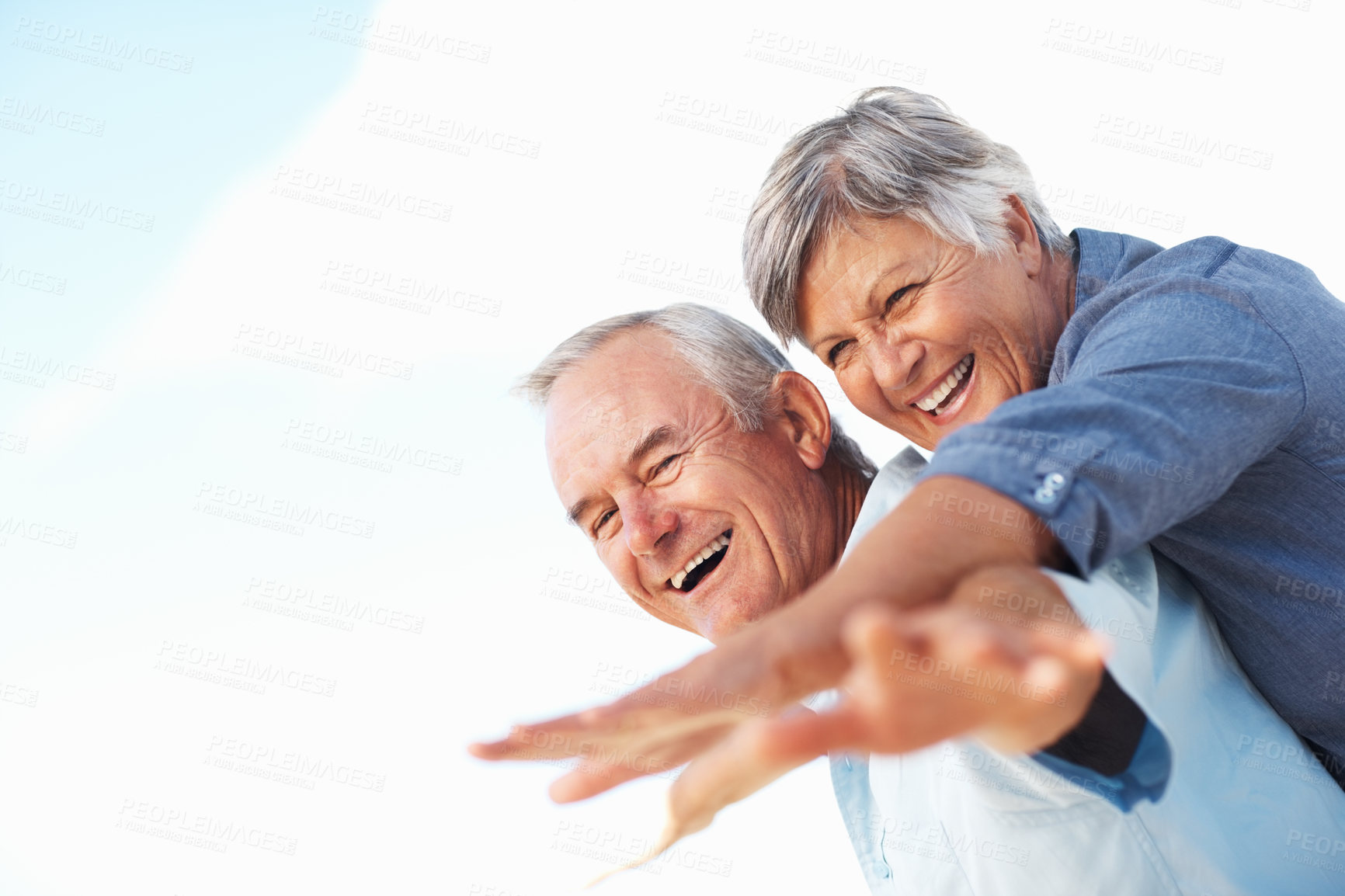 Buy stock photo Cheerful man piggybacking mature woman outdoors with hands outstretched