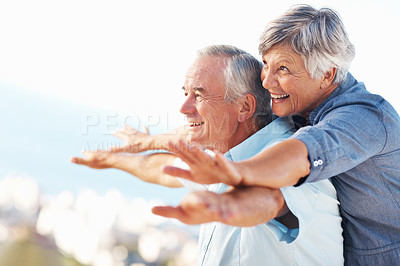 Buy stock photo Cheerful mature couple smiling while enjoying outdoors with arms outstretched