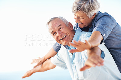 Buy stock photo Portrait of happy mature couple smiling while enjoying outdoors with arms outstretched