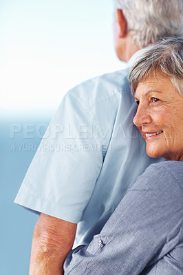 Buy stock photo Smiling mature woman hugging man from behind while spending time outdoors