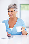 Mature woman with laptop drinking coffee