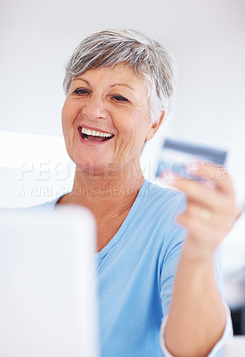 Buy stock photo Smiling mature woman shopping online using credit card and laptop