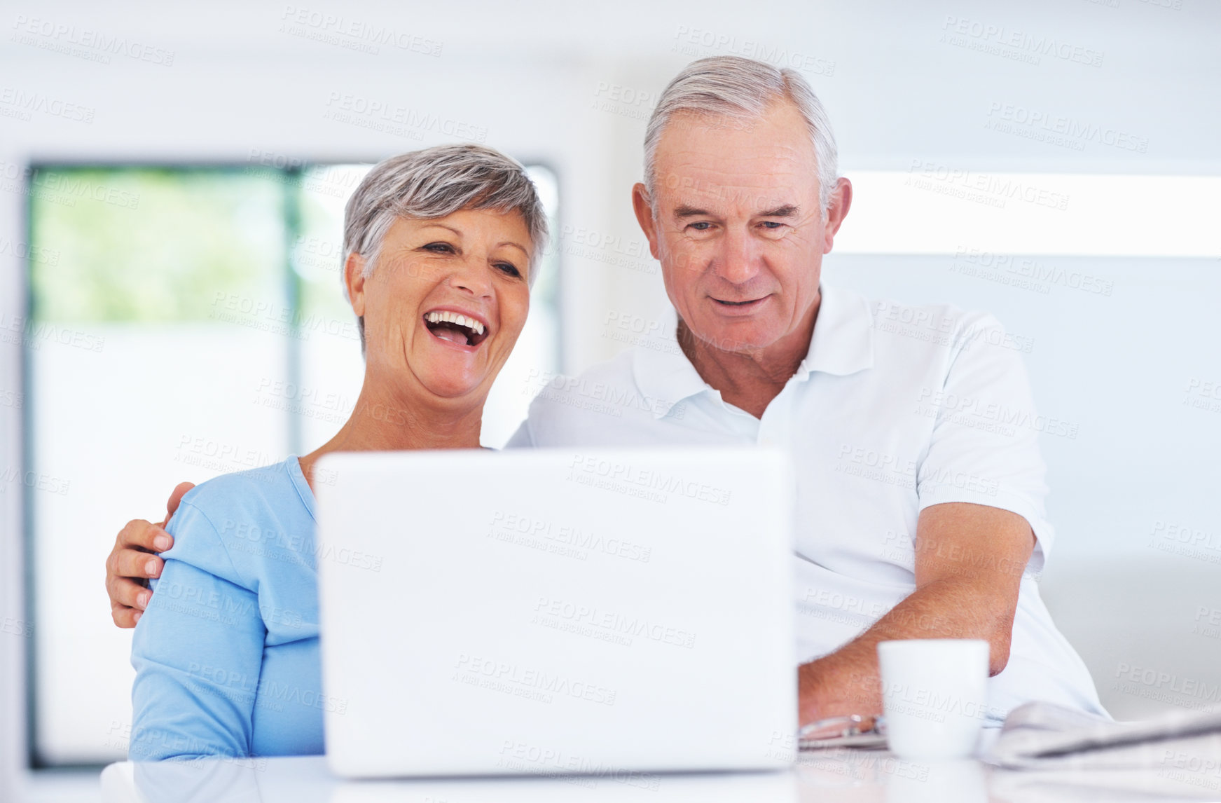 Buy stock photo Elderly man, woman and laugh with laptop, relax and watch live stream for funny video on web in home. Happy couple, computer and senior people in kitchen with comic memory, movie and story in house