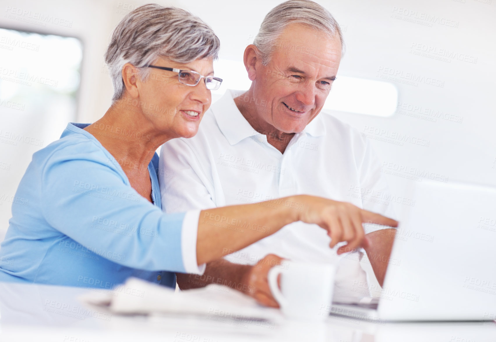 Buy stock photo Senior woman, man and laptop with coffee, smile and morning with reading, search and email in home. Happy couple, computer and elderly people in kitchen with notification, relax and point in house