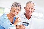 Smiling mature couple shopping online