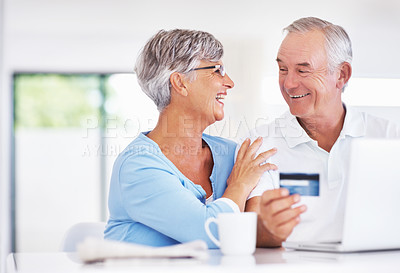 Buy stock photo Cheerful mature couple enjoying home shopping with credit card and laptop
