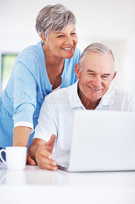 Buy stock photo Smiling mature man using laptop at home with woman looking at screen