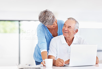 Buy stock photo Cheerful mature couple enjoying time together at home while using laptop