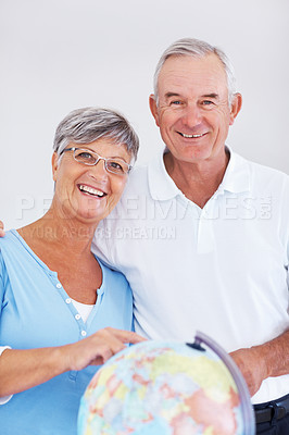 Buy stock photo Portrait of happy mature couple planning vacation while looking at globe